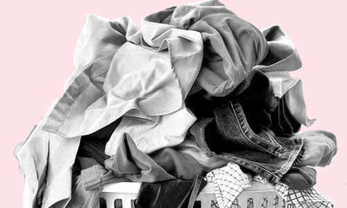 black and white photo of dirty laundry piled up in a laundry basket on a pink background.