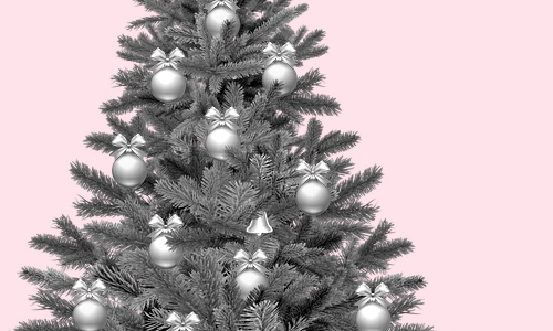photo of black and white christmas tree with silvery looking bulb ornaments on a pink background