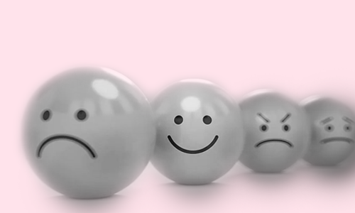 Black and white emojis, a sad face, a happy face in focus, an angry face, a really sad face... on a pink background